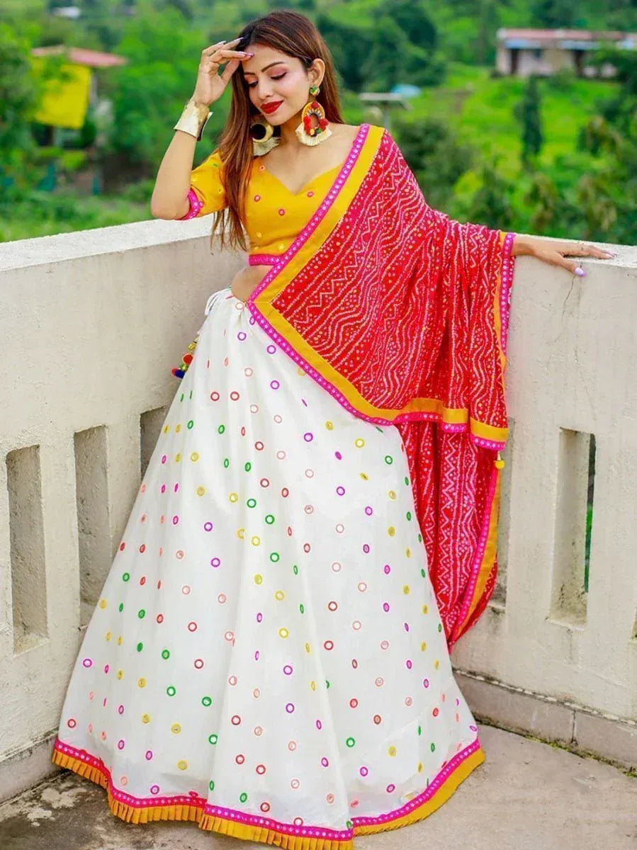 Woman in vibrant yellow choli with white polka dot lehenga and red dupatta, ethnic Indian wear