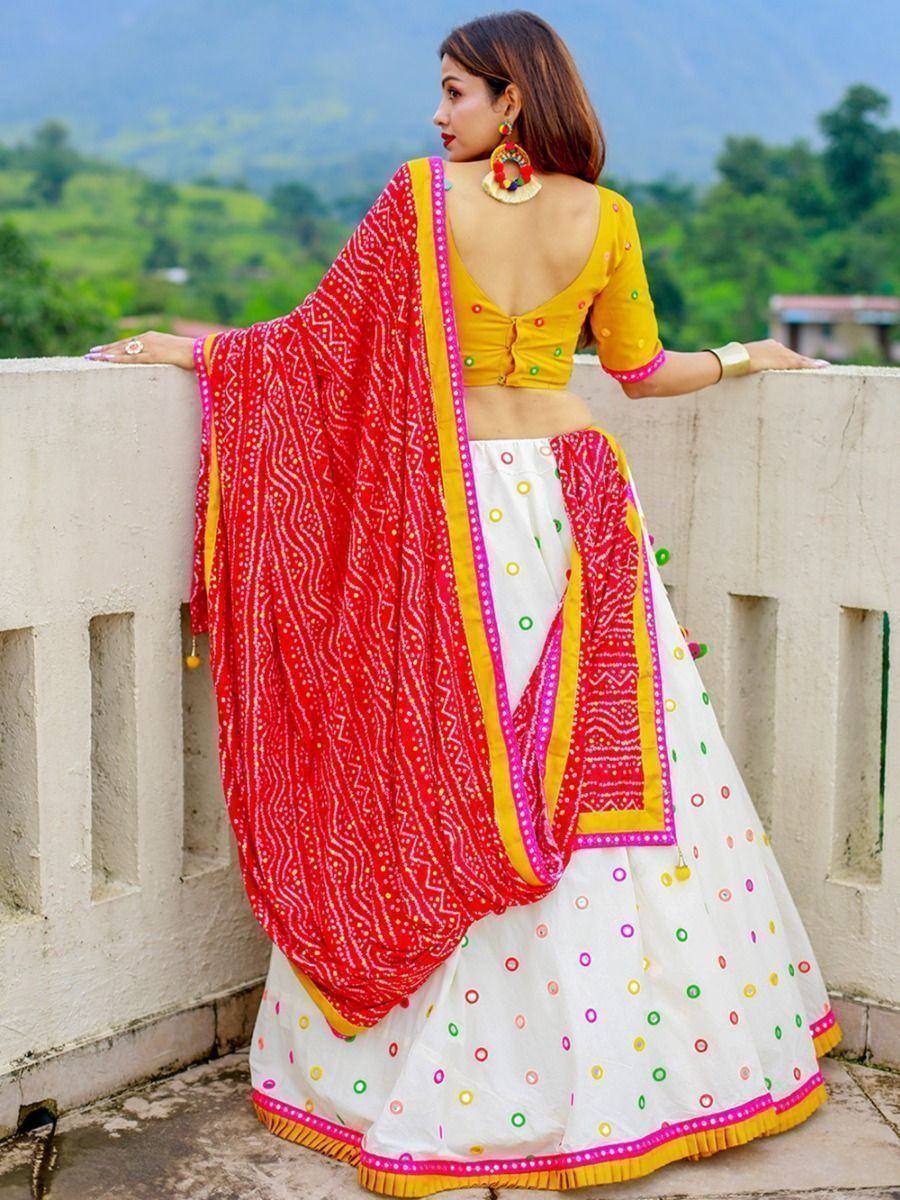 Woman in vibrant yellow and white lehenga choli with red dupatta, ethnic Indian wear for festive occasions