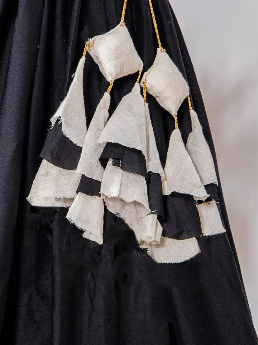 Black ethnic gown with layered off-white fabric tassels and gold trim detailing