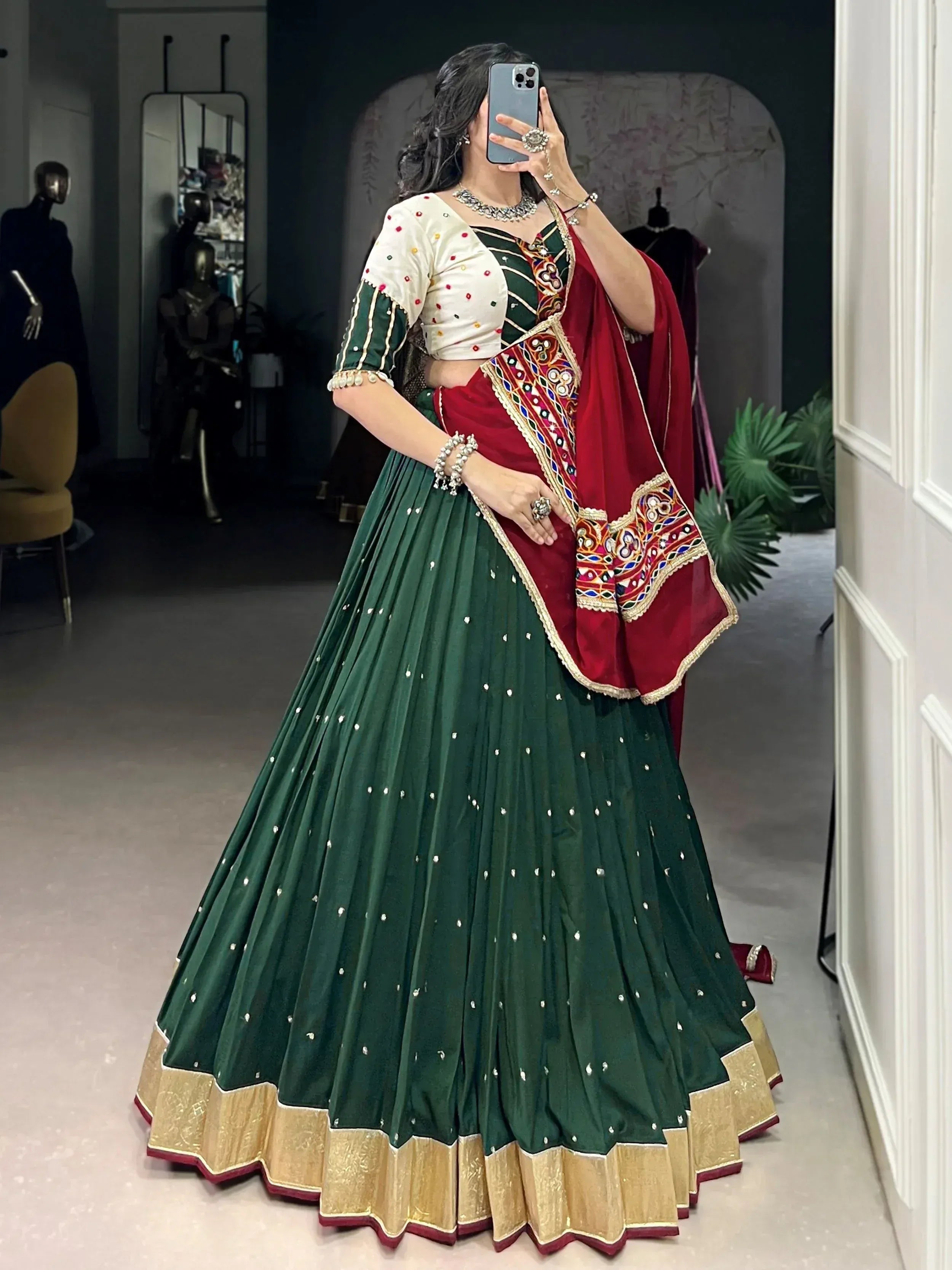 Green and red embroidered lehenga choli with mirror work, perfect for Indian ethnic wear and festive occasions.