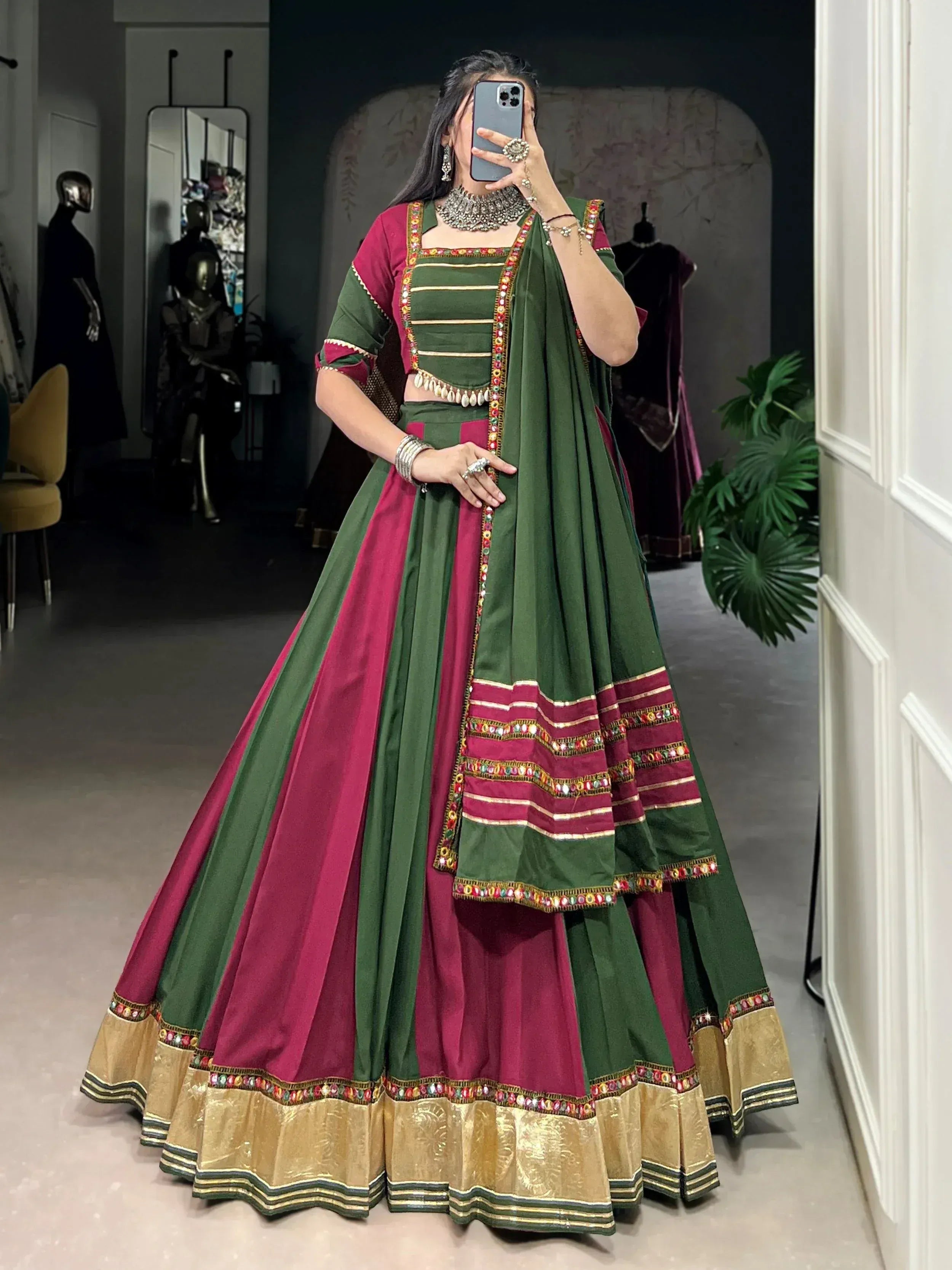 Green and maroon Indian lehenga choli with mirror work and gold border, perfect for festive occasions