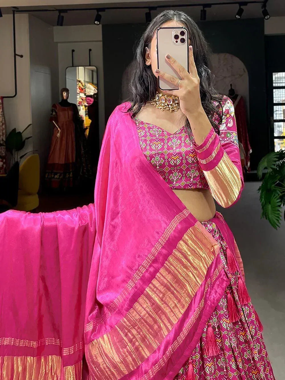 Vibrant pink ethnic lehenga choli with geometric print, gold trim, and matching dupatta for festive occasions