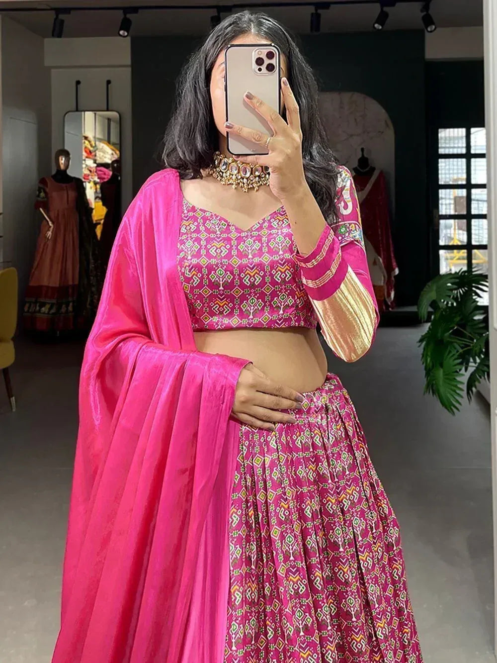 Pink printed lehenga choli with gold sleeves and dupatta, styled with statement necklace