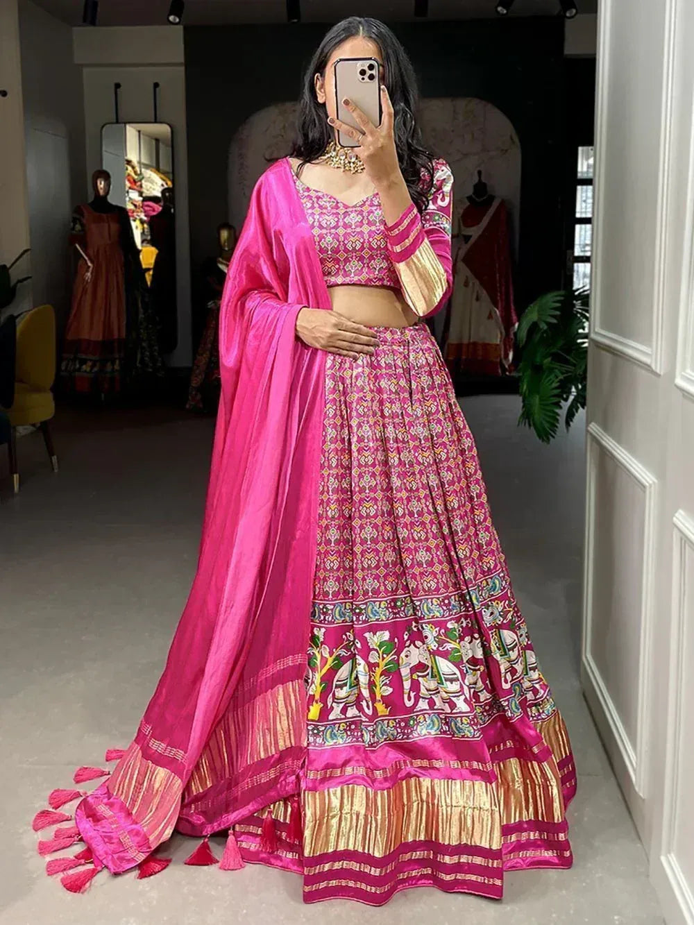 Vibrant pink lehenga choli with elephant print, gold border, and matching dupatta for Indian ethnic wear
