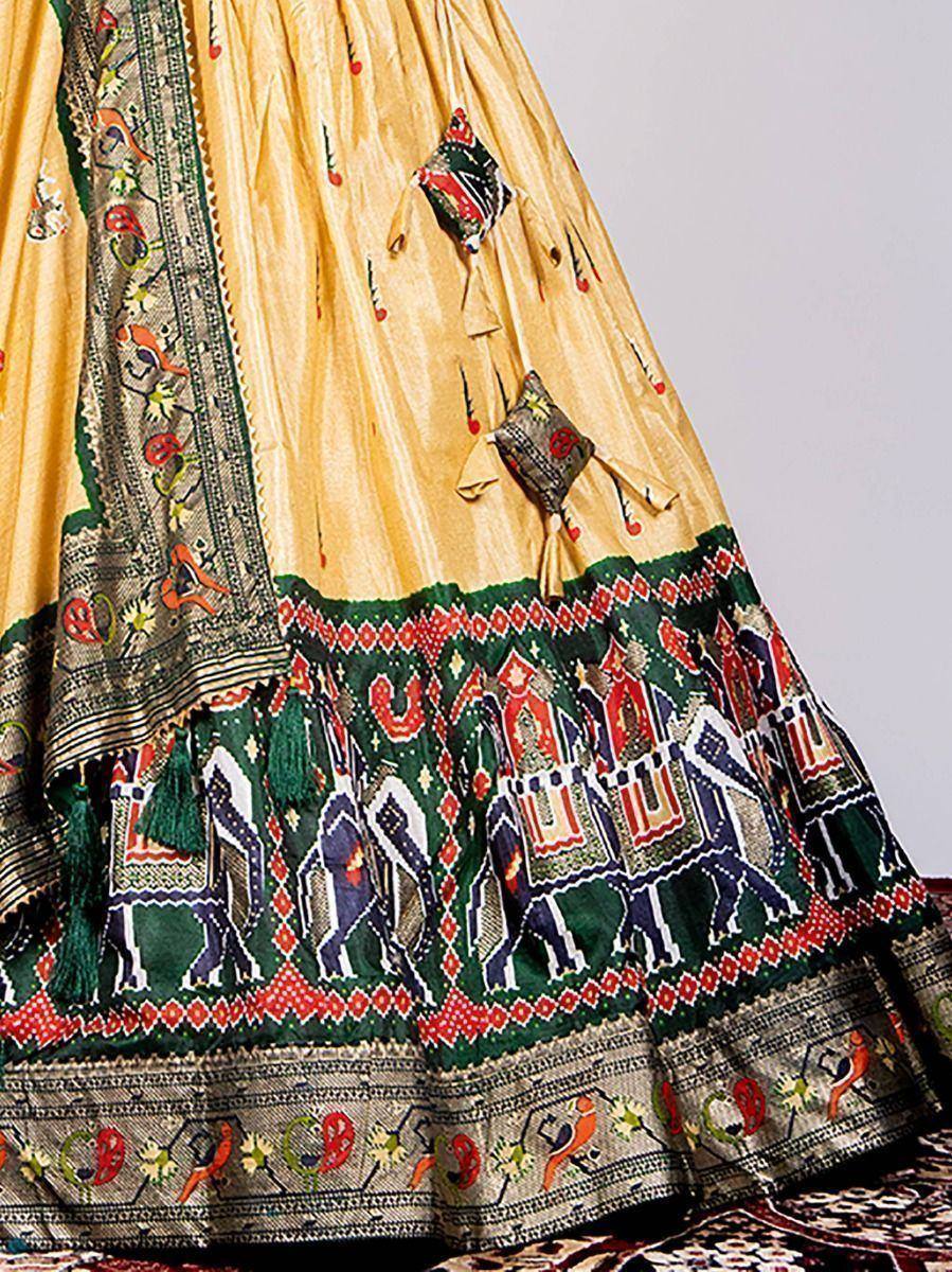 Yellow ethnic lehenga with green border, elephant print, and tassel details for Indian weddings