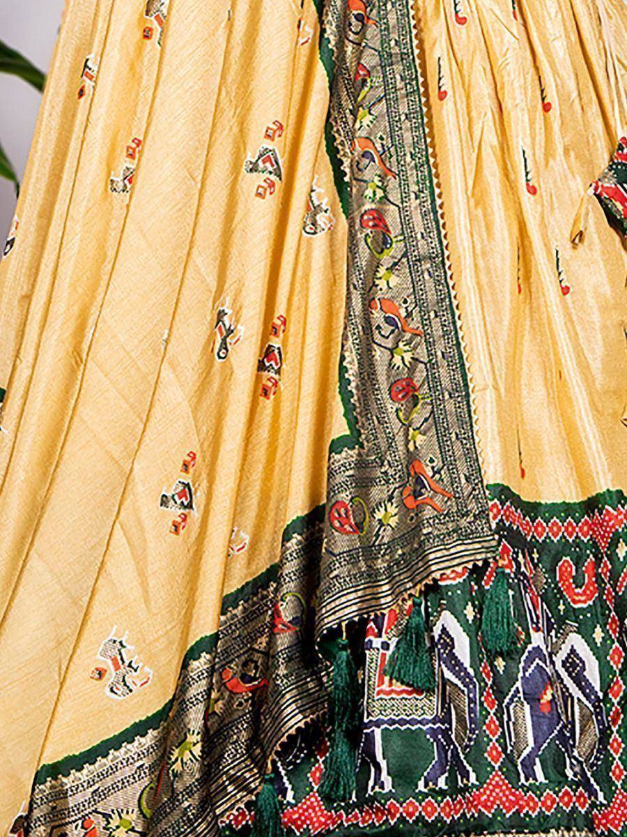 Yellow ethnic lehenga with elephant print, green border, and tassels, perfect for festive occasions