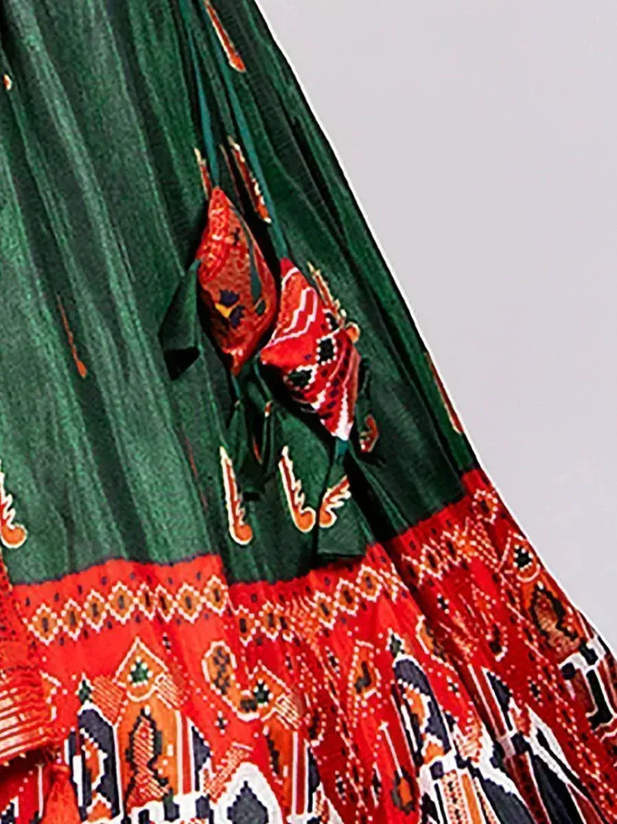 Green and red ethnic printed lehenga with intricate geometric patterns and tassels