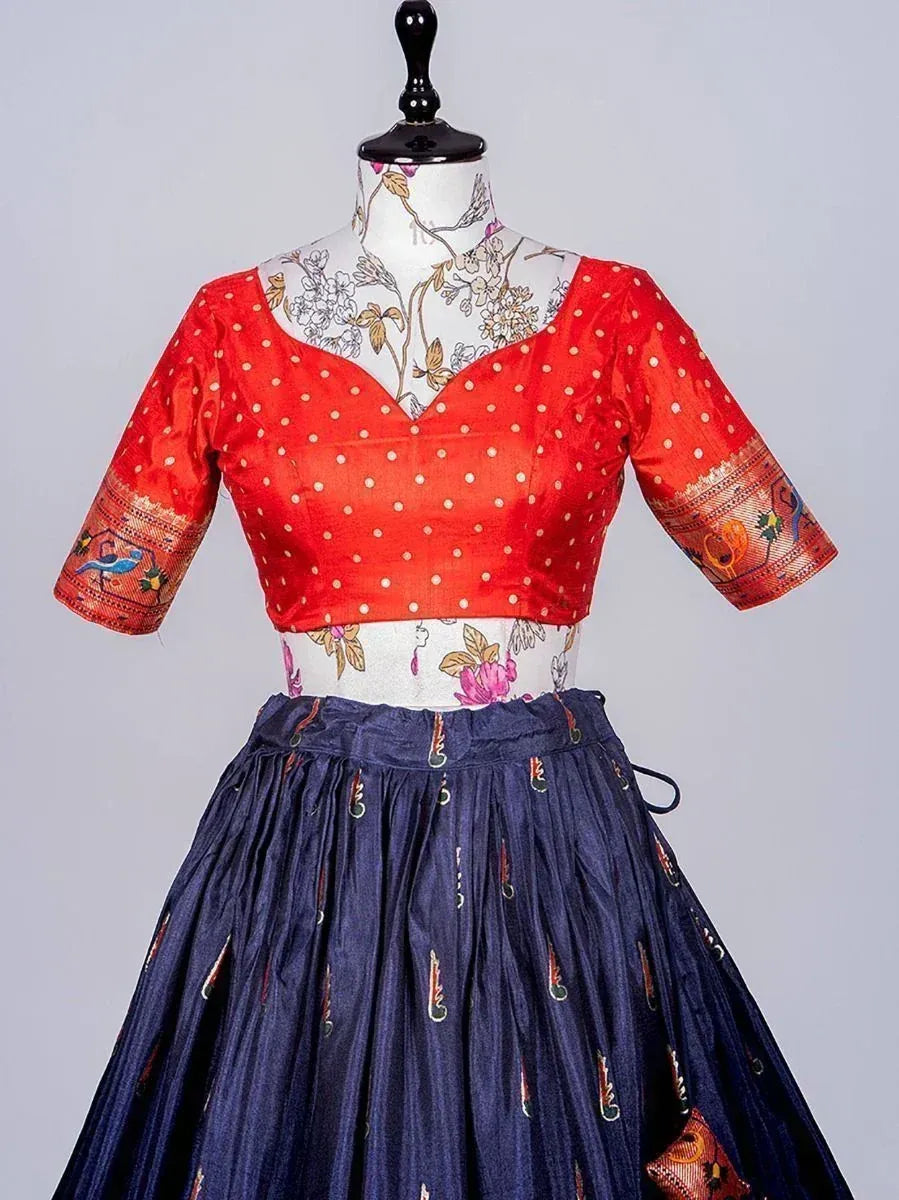 Red polka dot blouse with embroidered sleeves paired with navy blue pleated skirt, ethnic wear