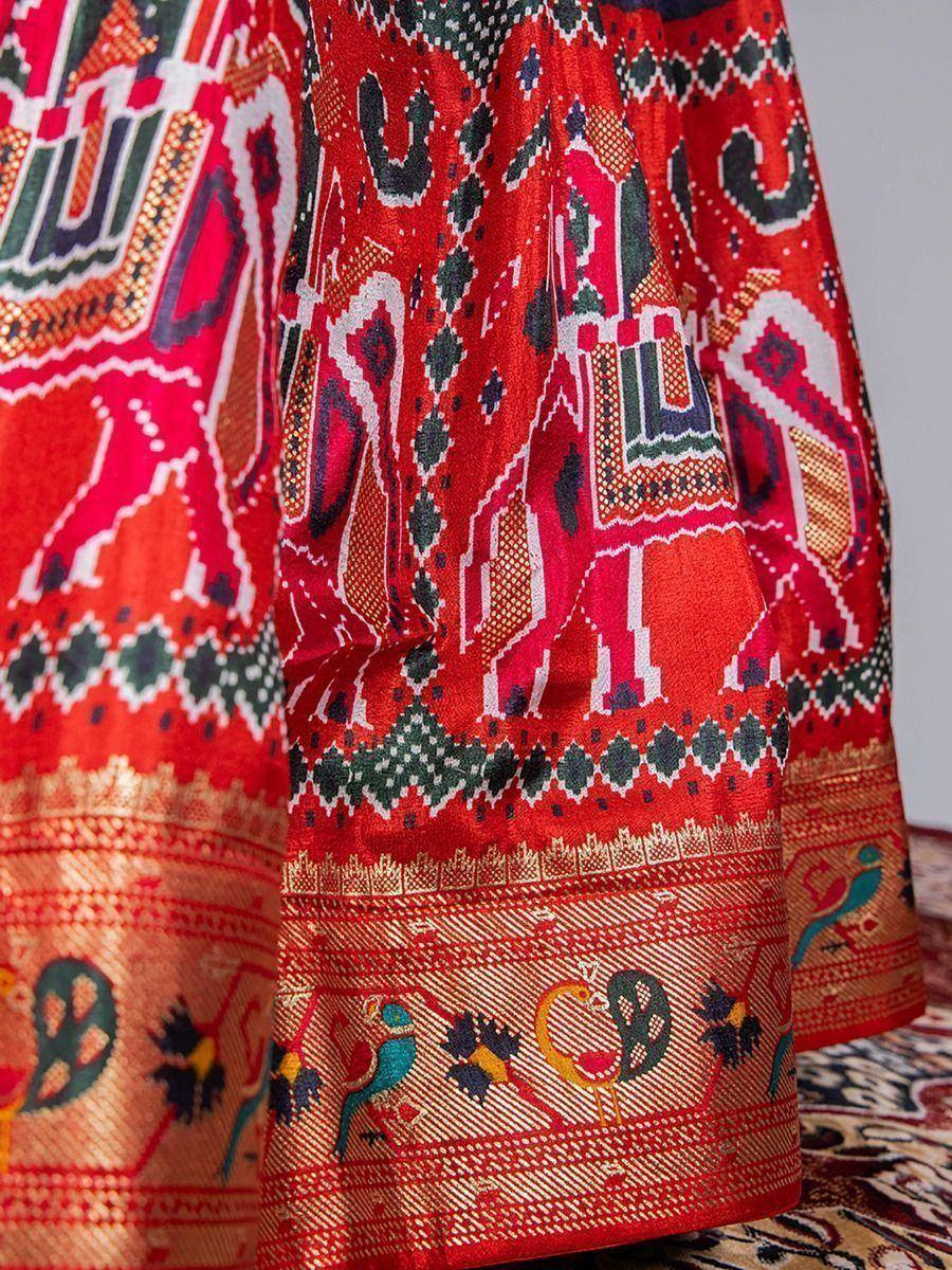 Red ethnic lehenga with elephant & peacock motifs, intricate border design, traditional Indian wear