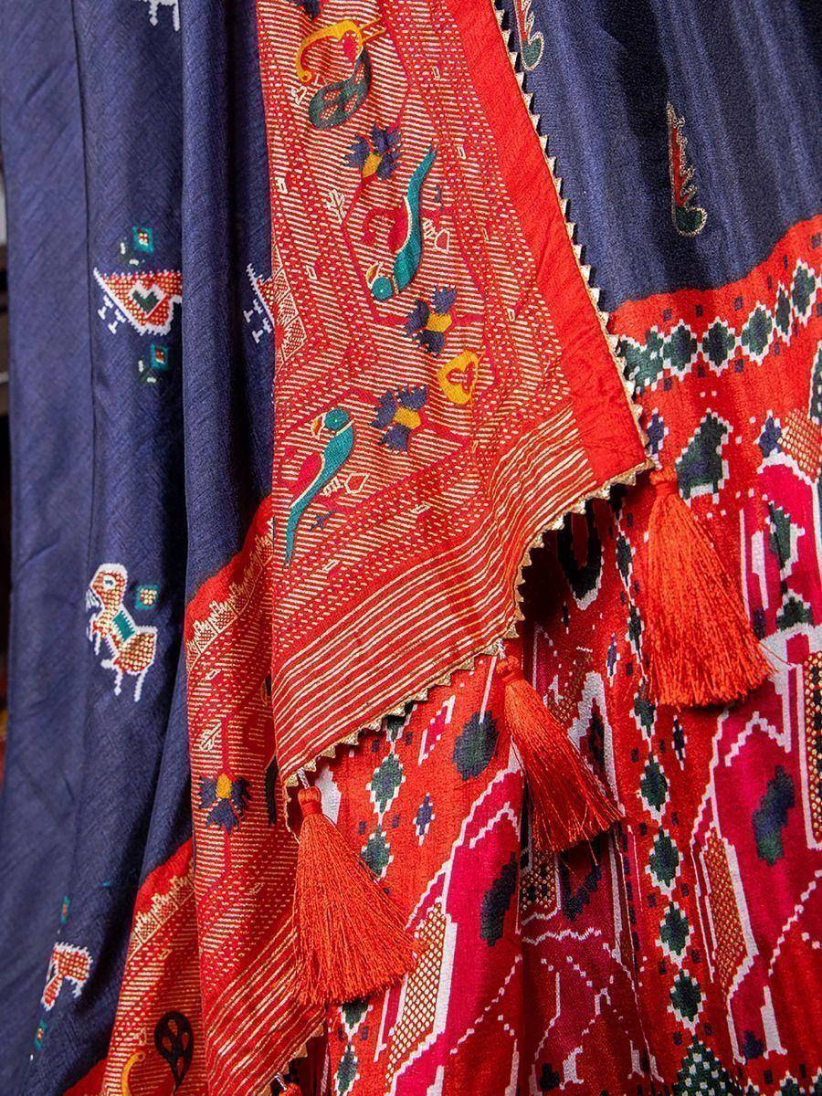 Vibrant red and navy ethnic lehenga with bird motifs, tassels, and geometric embroidery for festive occasions