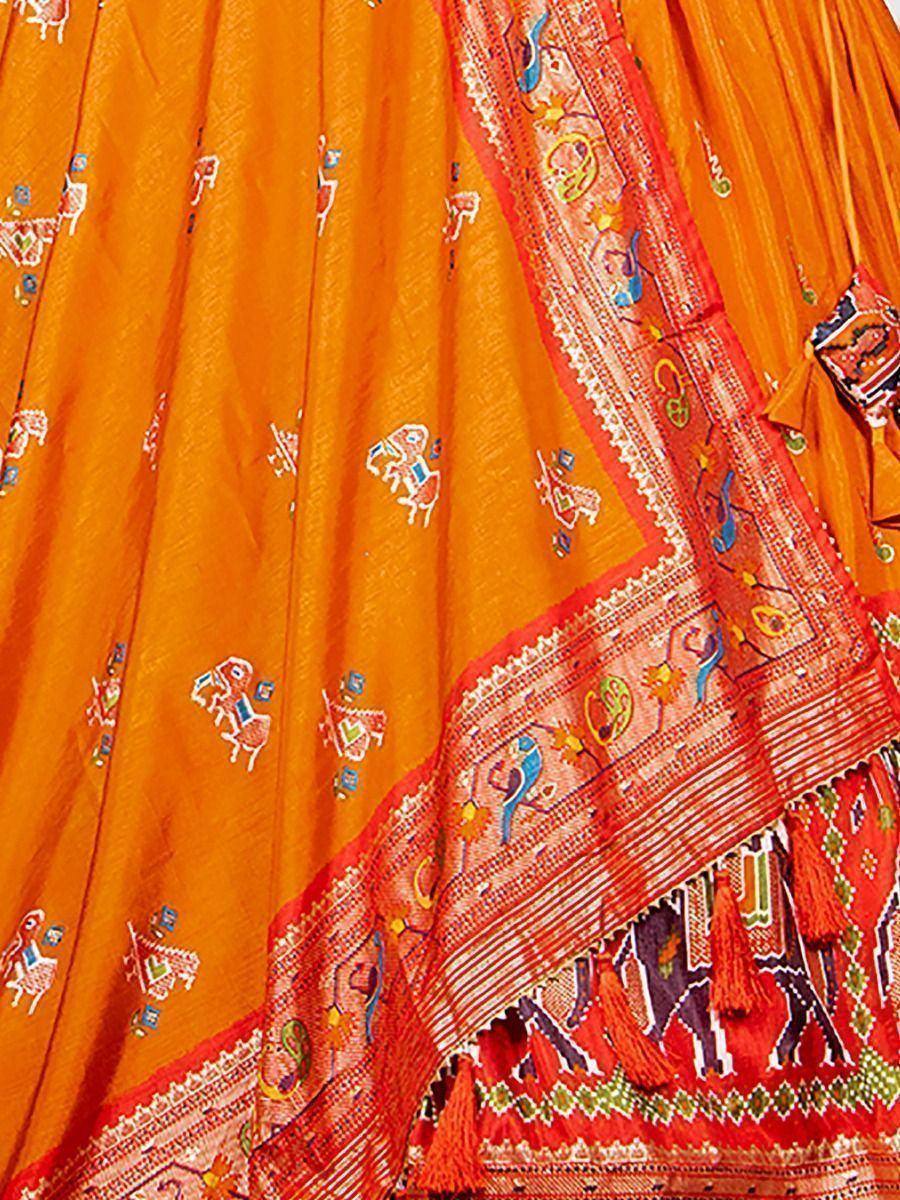 Vibrant orange ethnic lehenga with intricate embroidery and colorful tassels, perfect for festive occasions.