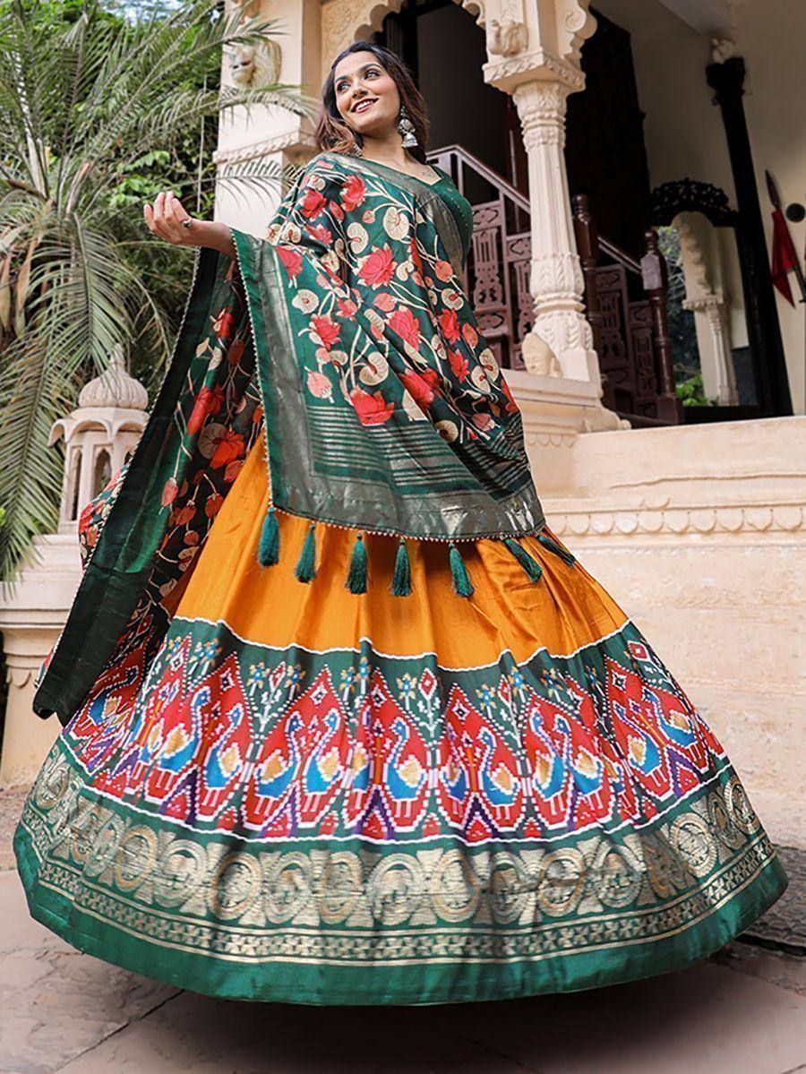 Woman in vibrant green and orange floral lehenga choli with tassels, perfect for Indian ethnic wear occasions