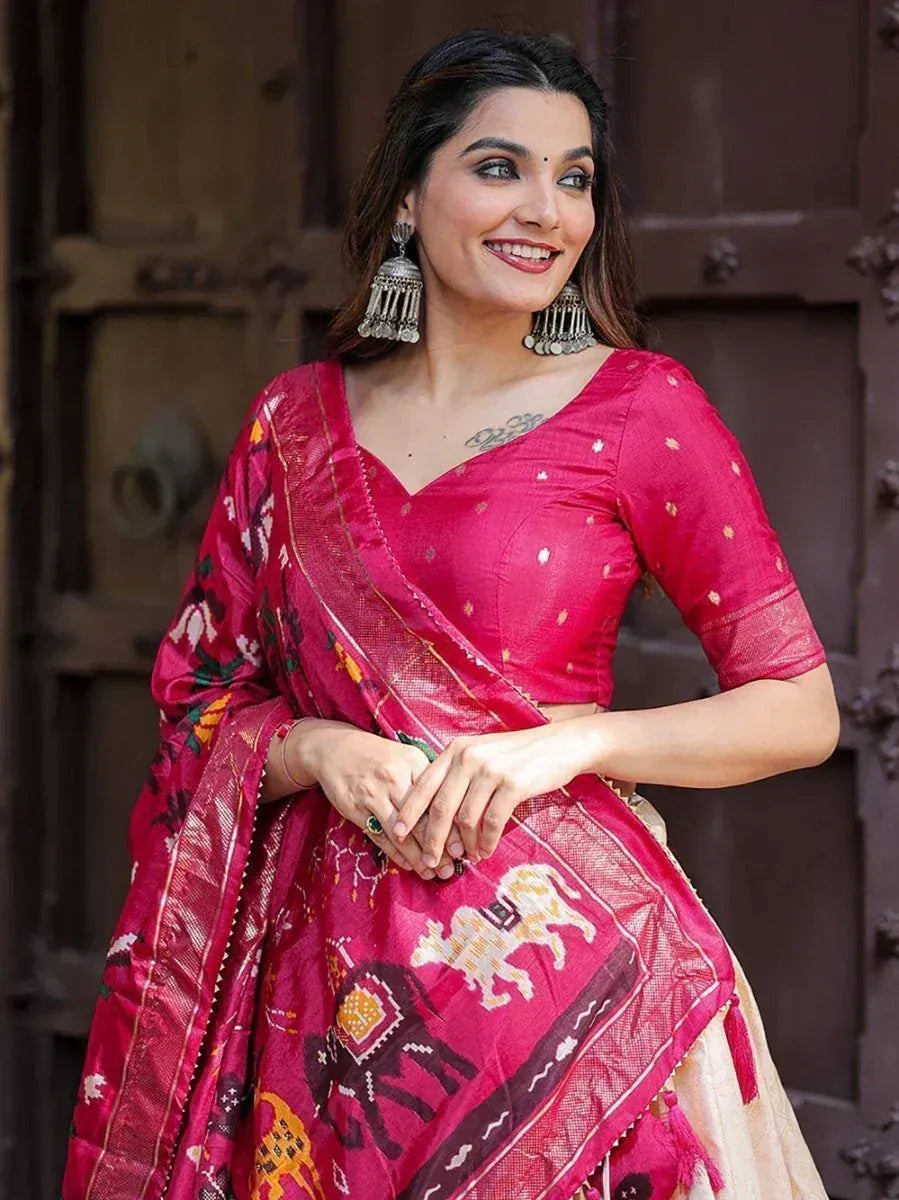 Woman in vibrant pink ethnic saree with elephant print, traditional jewelry, and designer blouse
