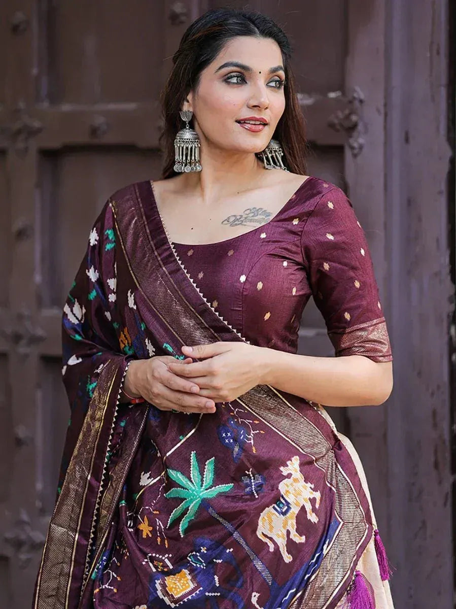 Woman in maroon embroidered saree with elephant & palm motifs, ethnic Indian wear