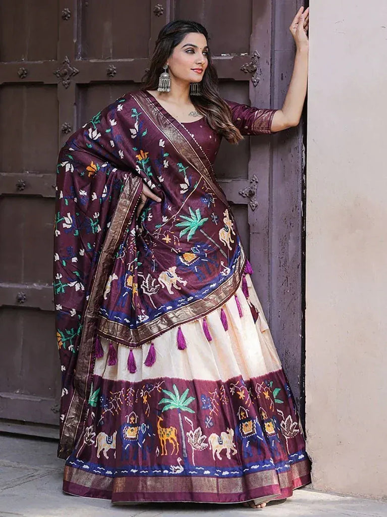 Woman in maroon embroidered saree with elephant & palm motifs, ethnic Indian wear