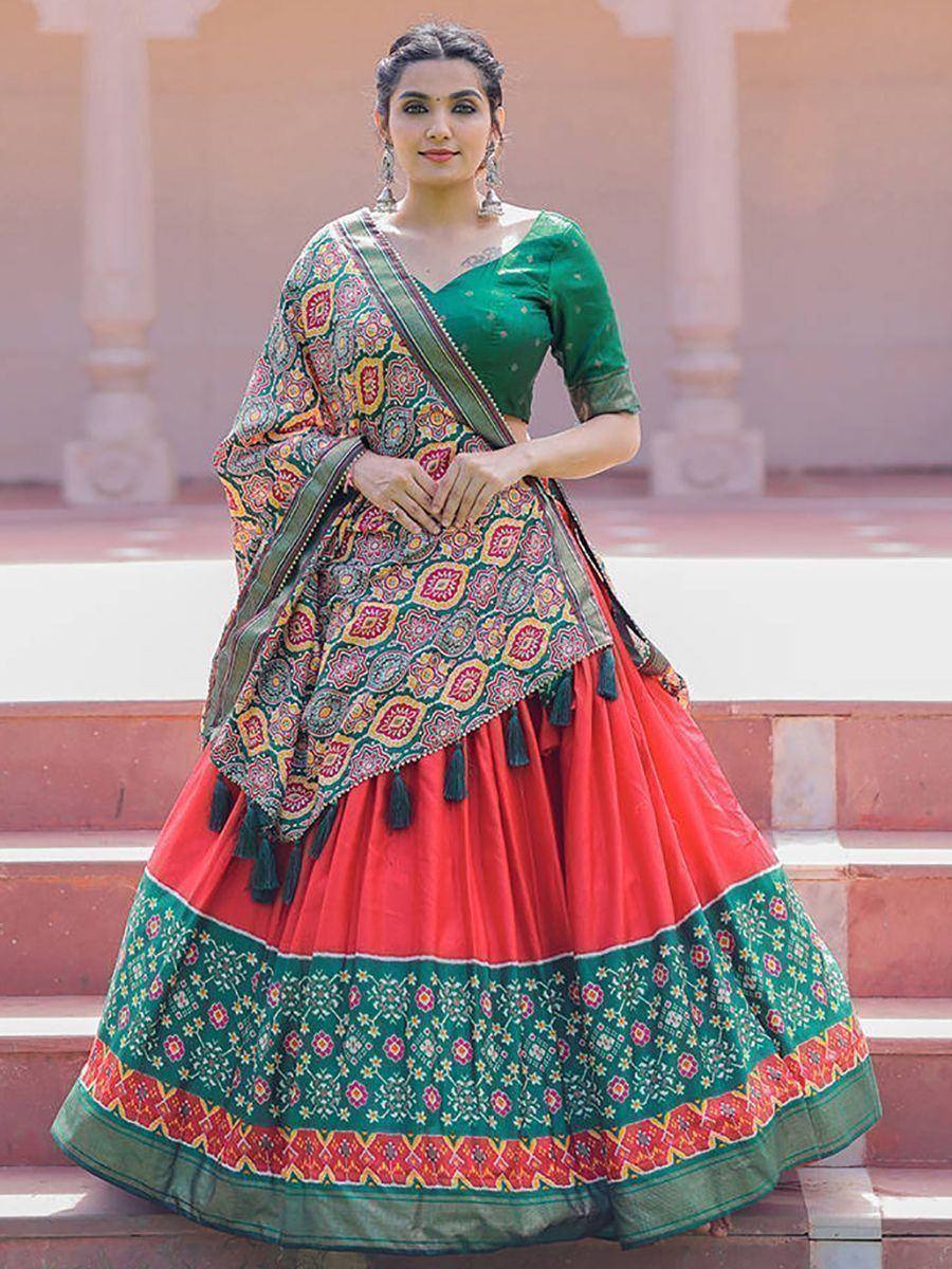 Green and red ethnic lehenga choli with floral print and tassels, perfect for Indian weddings and festivals