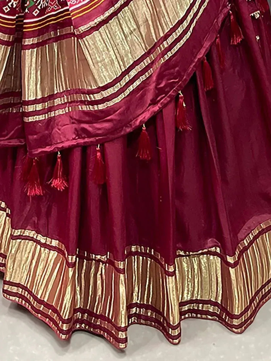 Maroon ethnic lehenga with gold stripes and tassels, designer Indian wear