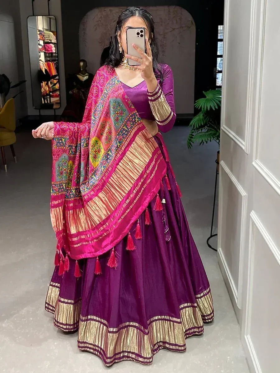 Purple lehenga choli with pink embroidered dupatta, gold trim, and tassels for Indian ethnic wear