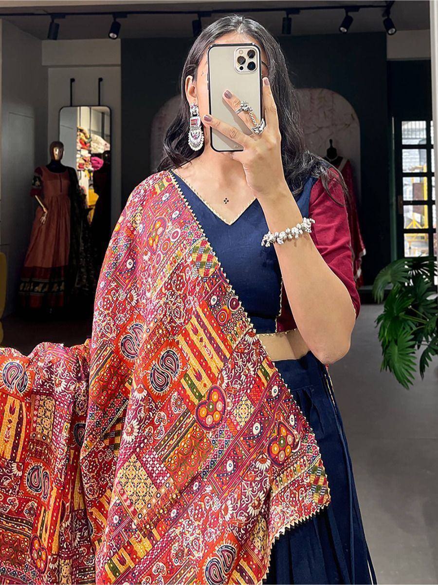 Woman in vibrant printed dupatta with navy blue lehenga choli, ethnic Indian wear