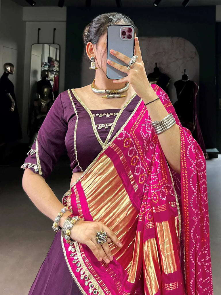Woman in purple blouse and pink patterned saree with gold border, traditional Indian ethnic wear