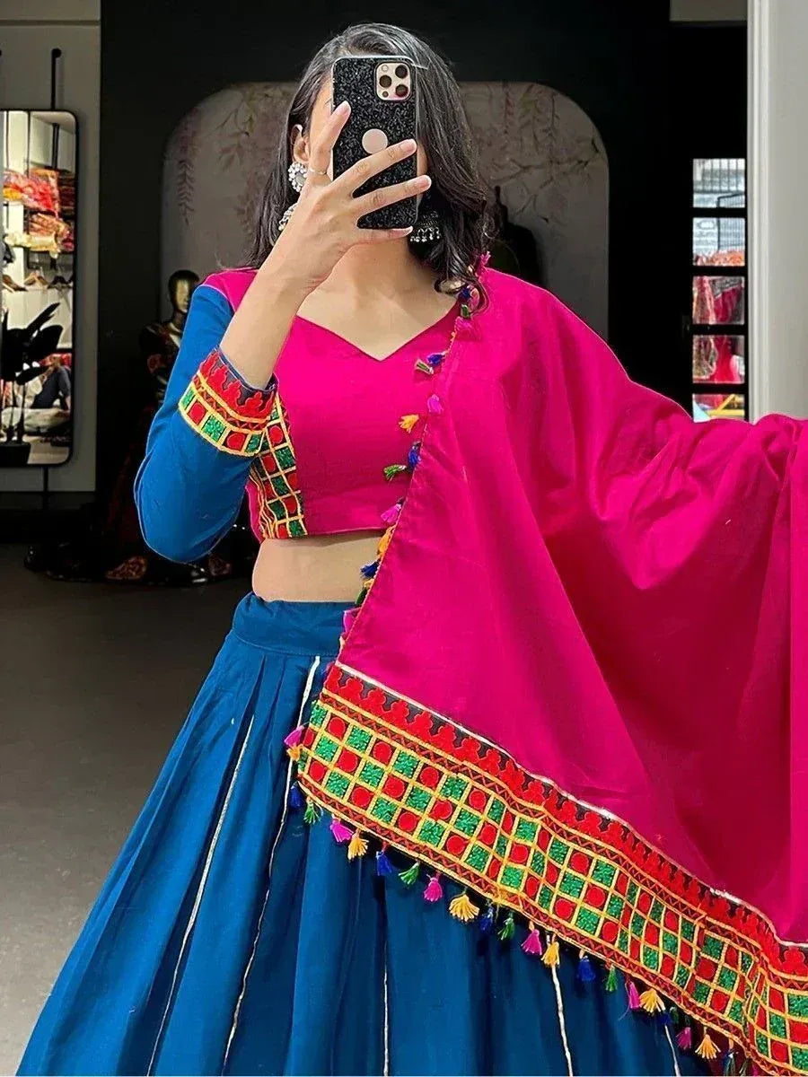 Vibrant pink and blue ethnic lehenga choli with colorful embroidery and tassels, perfect for festive occasions.