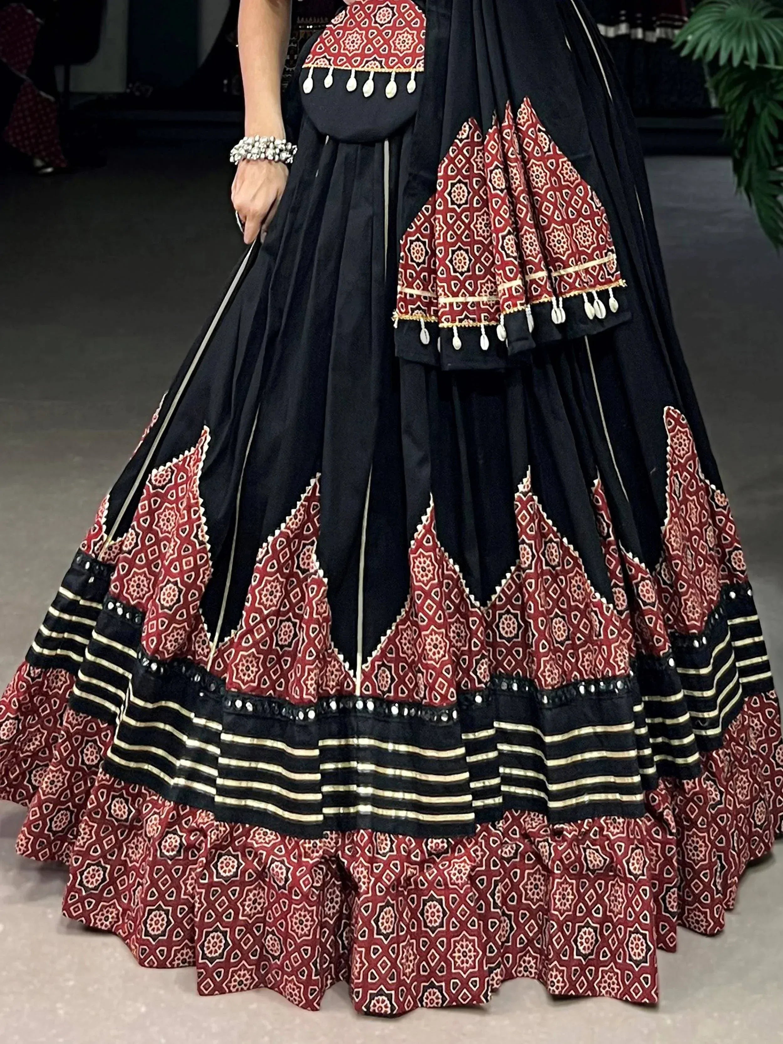 Black and red ethnic lehenga with geometric print, tassels, and layered skirt for Indian wear