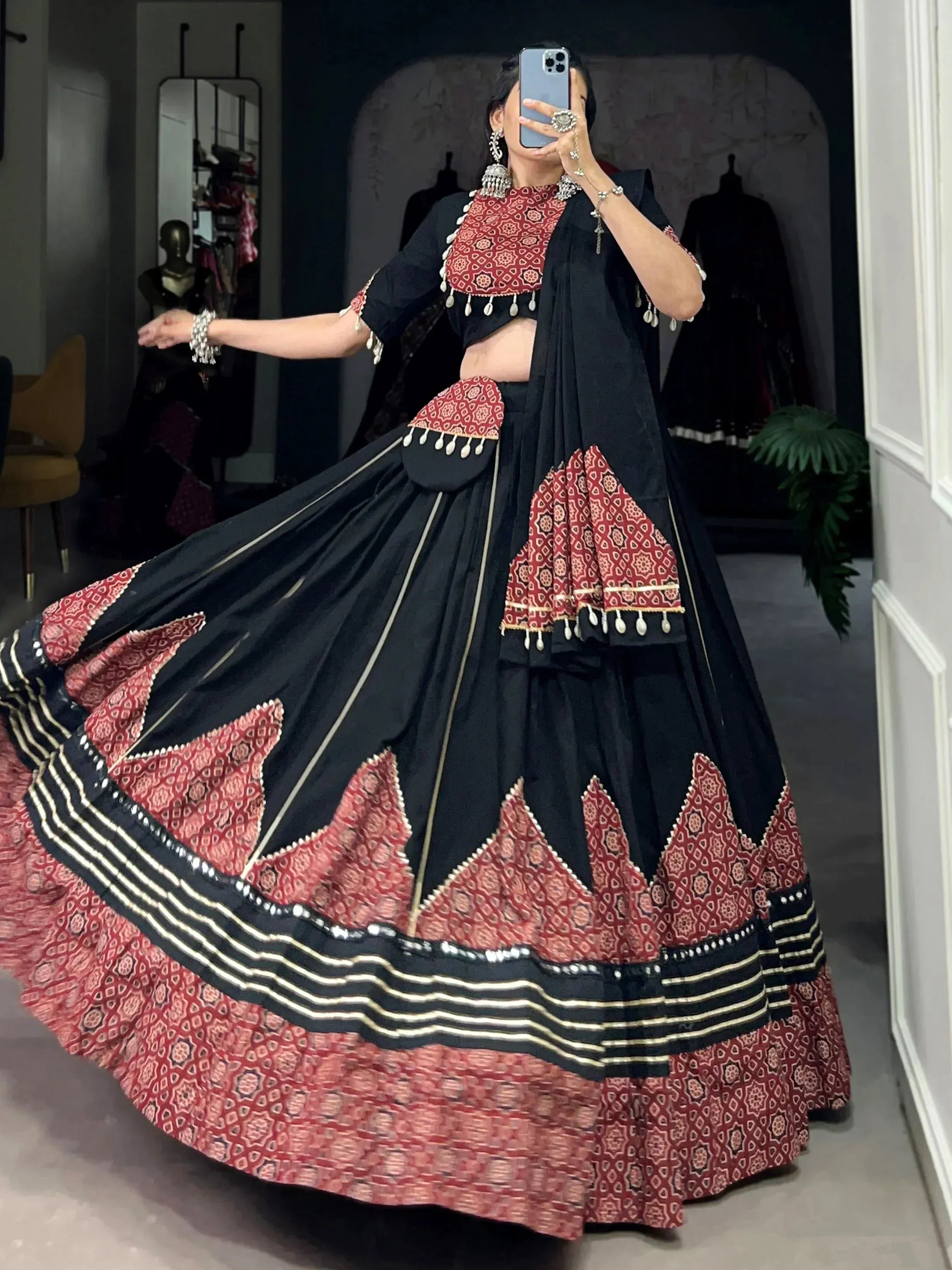 Black and red ethnic lehenga choli with geometric print and gold trim, perfect for Indian weddings or festive occasions.