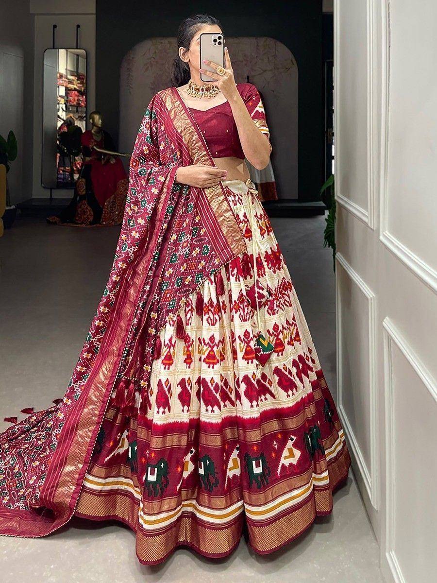 Woman in maroon and cream Ikat lehenga choli with elephant motifs, perfect for ethnic occasions