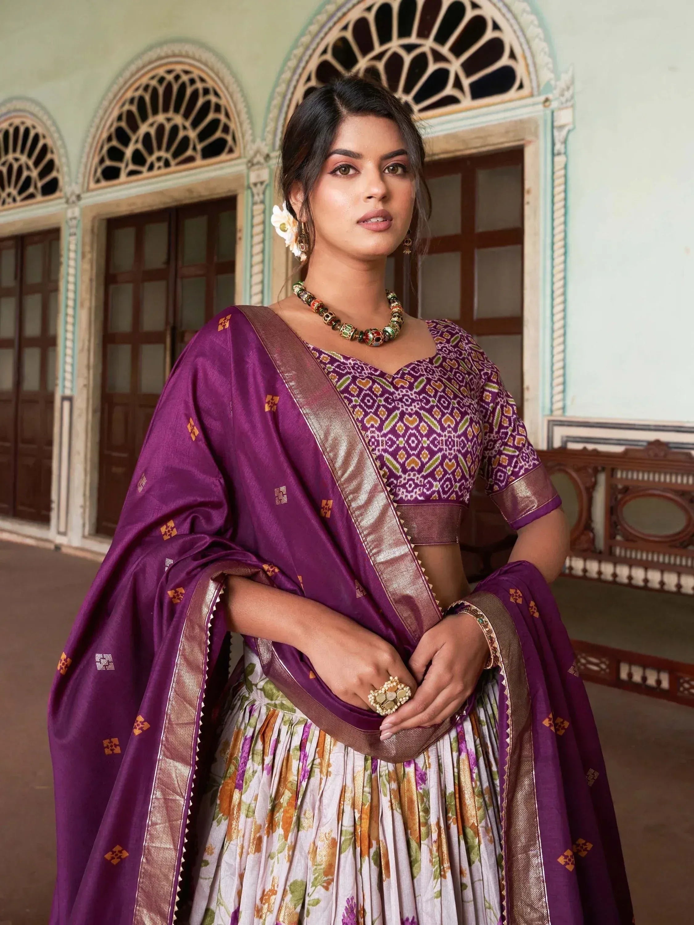 Purple ethnic lehenga choli with floral skirt and gold border, perfect for Indian weddings and festivals