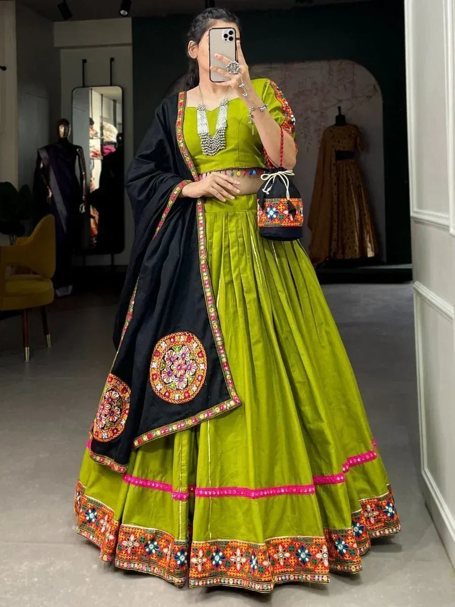 Vibrant green lehenga choli with black dupatta, colorful embroidery, and mirror work for festive occasions.