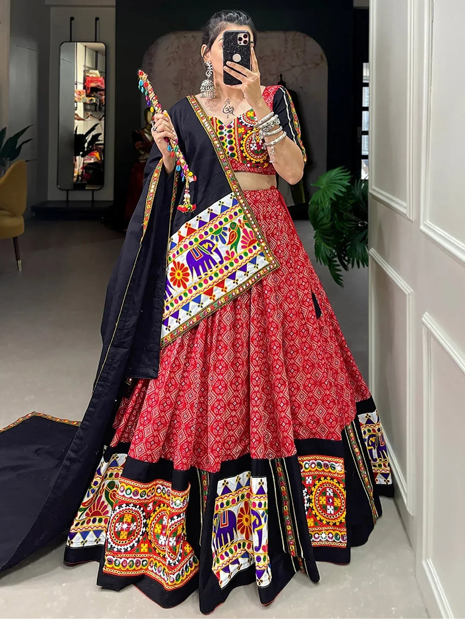 Vibrant red and black embroidered lehenga choli with mirror work, perfect for Indian ethnic wear occasions.