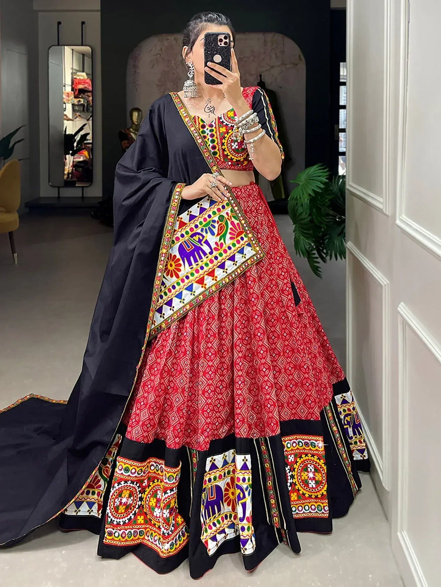 Vibrant red and black embroidered lehenga choli with colorful mirror work and elephant motifs, perfect for Indian ethnic wear.