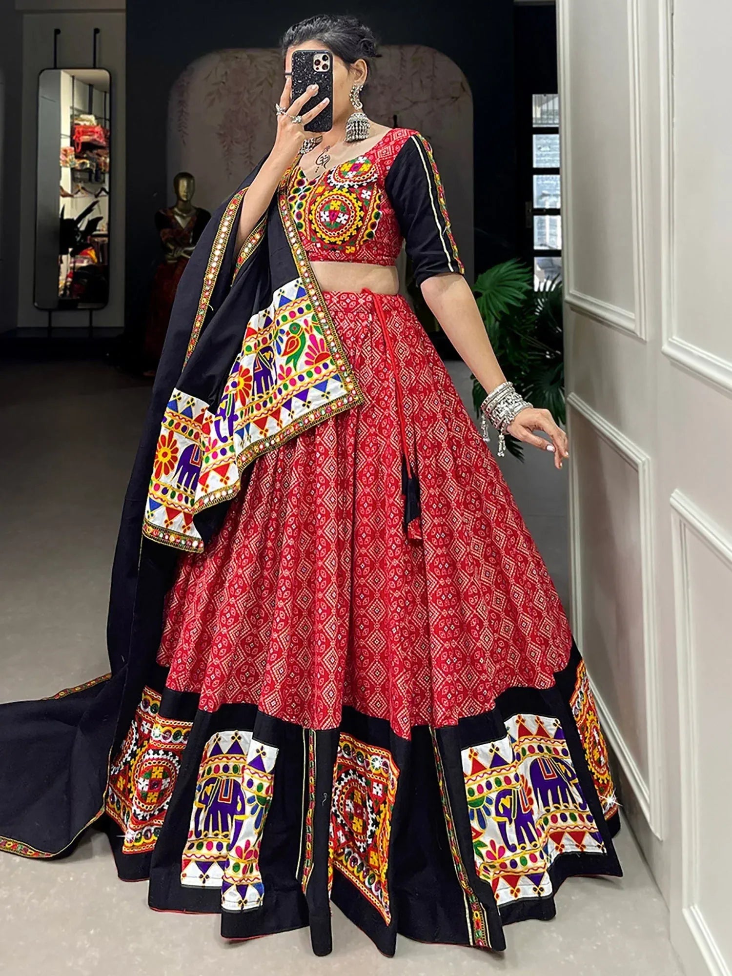 Red and black embroidered lehenga choli with colorful mirror work and elephant motifs, perfect for Indian ethnic wear.
