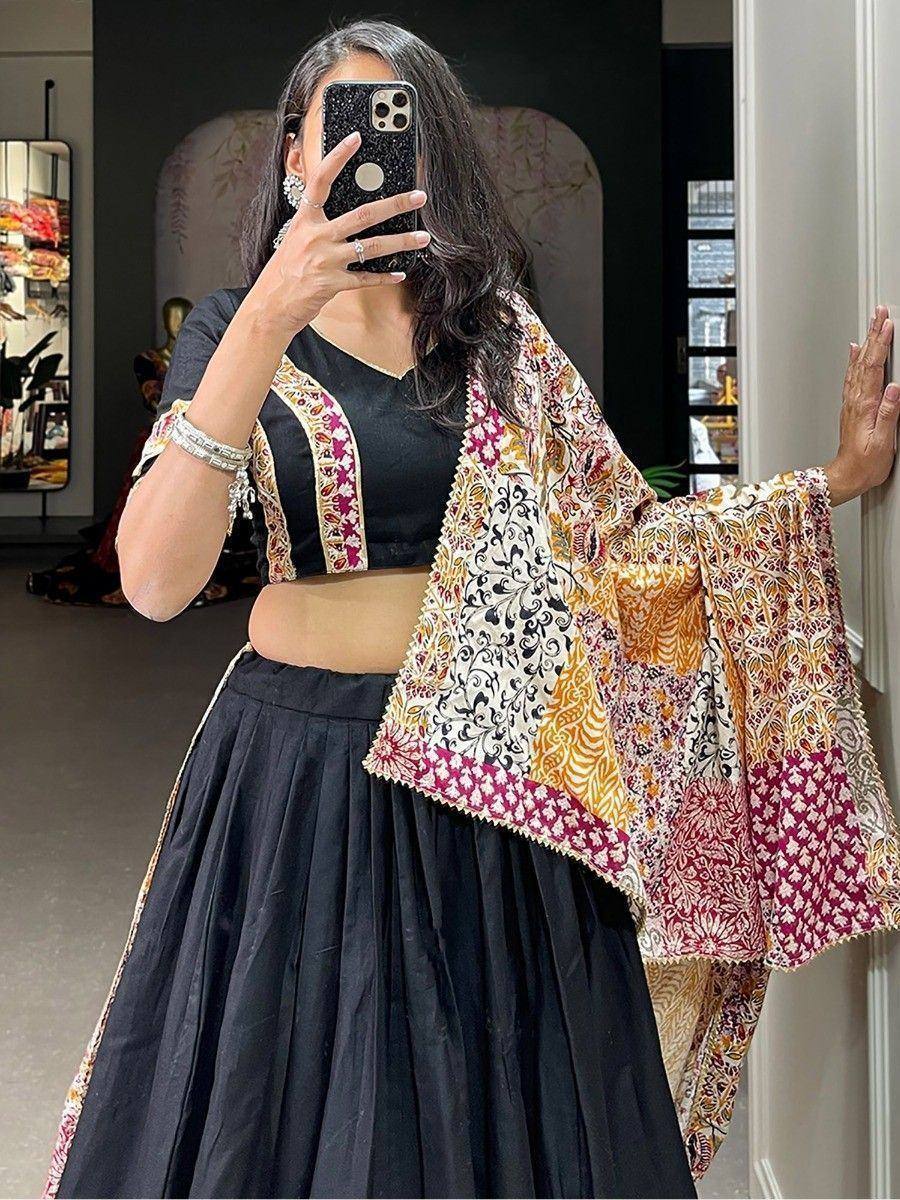 Woman in black lehenga choli with colorful printed dupatta, ethnic Indian wear