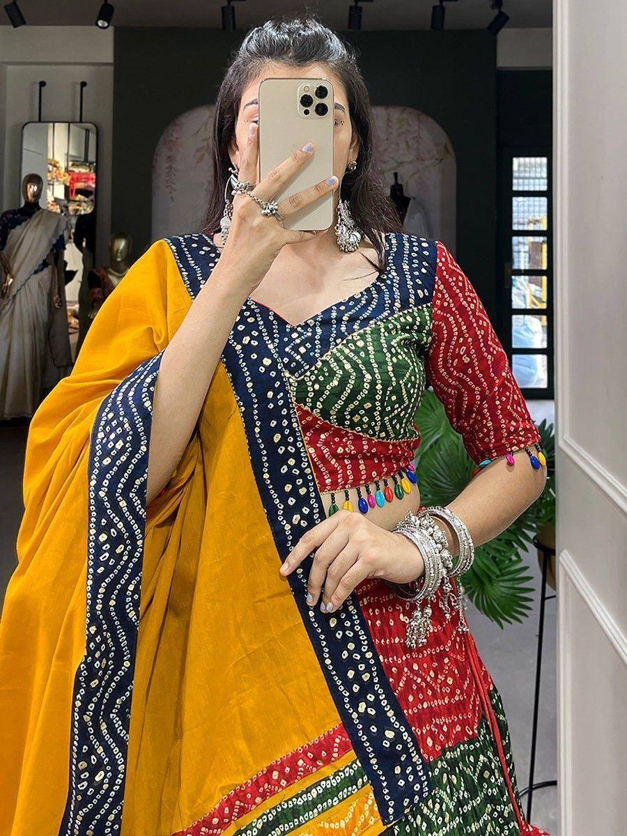 Woman in colorful Indian ethnic saree with mirror work, taking mirror selfie in boutique