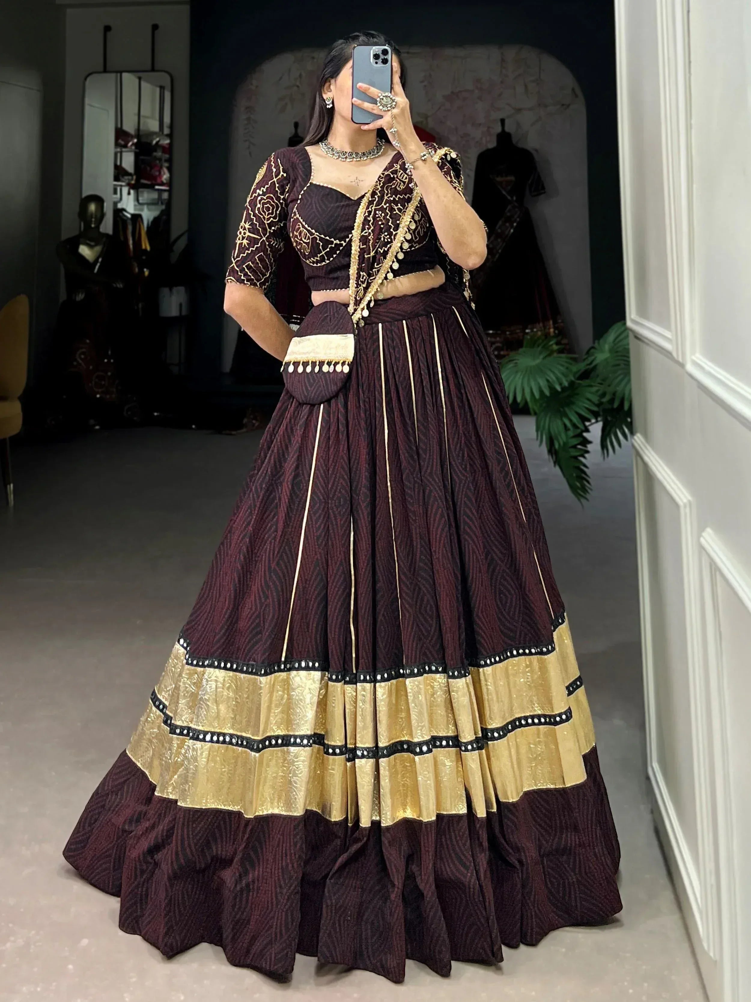 Maroon and gold embroidered lehenga choli with mirror work, perfect for Indian ethnic wear occasions.