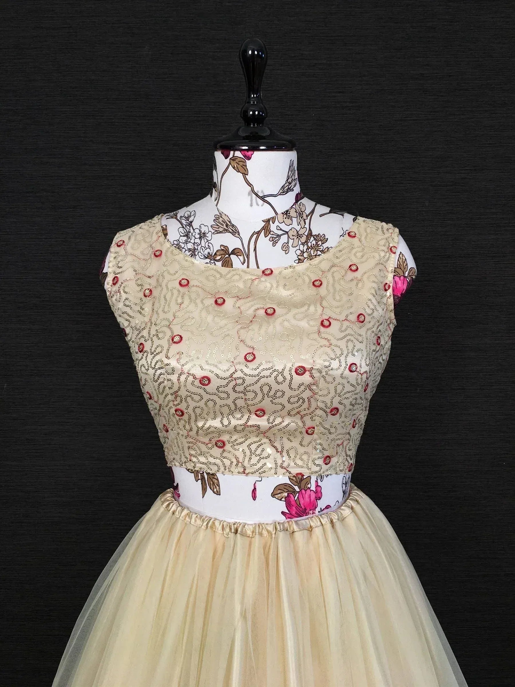 Beige ethnic gown with floral embroidery and sequin detailing, displayed on mannequin