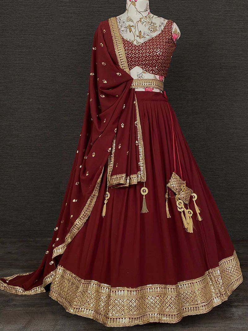 Maroon designer lehenga choli with gold embroidery and tassels, perfect for Indian weddings and festive occasions