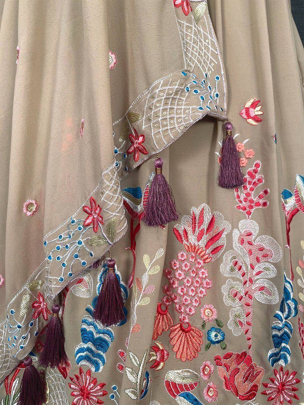 Beige ethnic gown with floral embroidery, tassels, and mirror work for Indian occasions