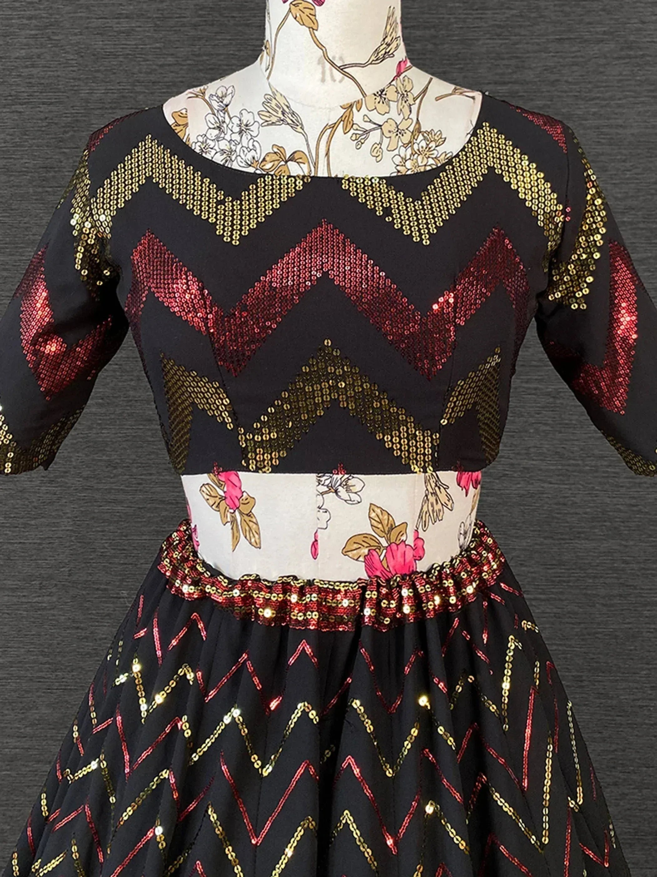 Black ethnic gown with red & gold sequin chevron pattern, floral waistband, perfect for festive occasions.