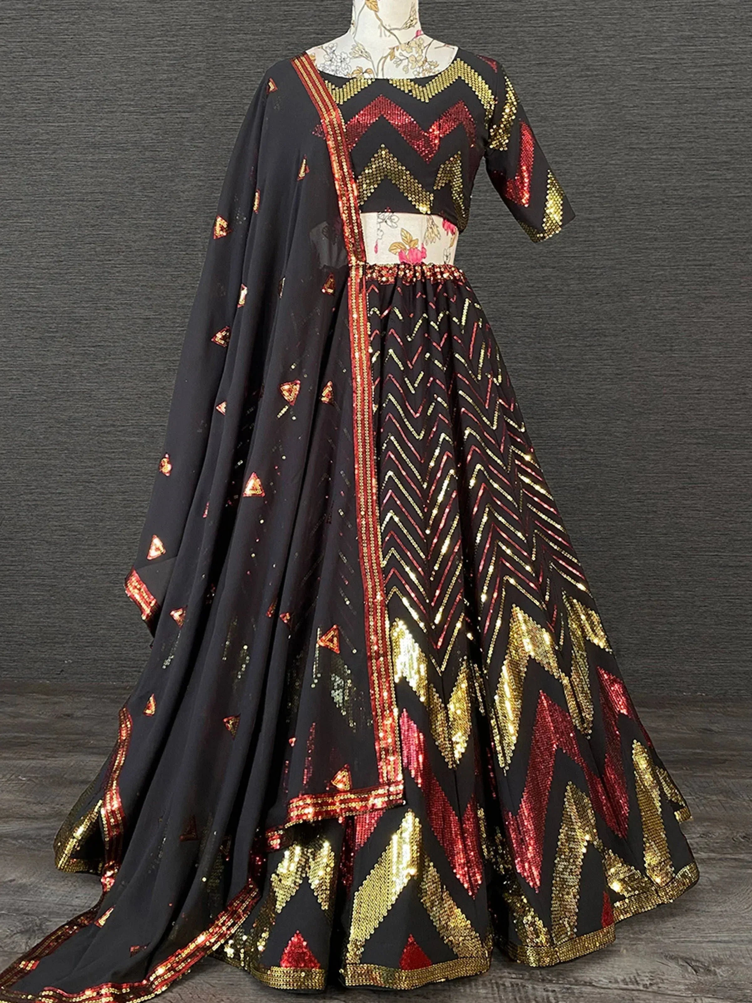 Black designer lehenga choli with red gold sequin chevron patterns, perfect for Indian ethnic wear events