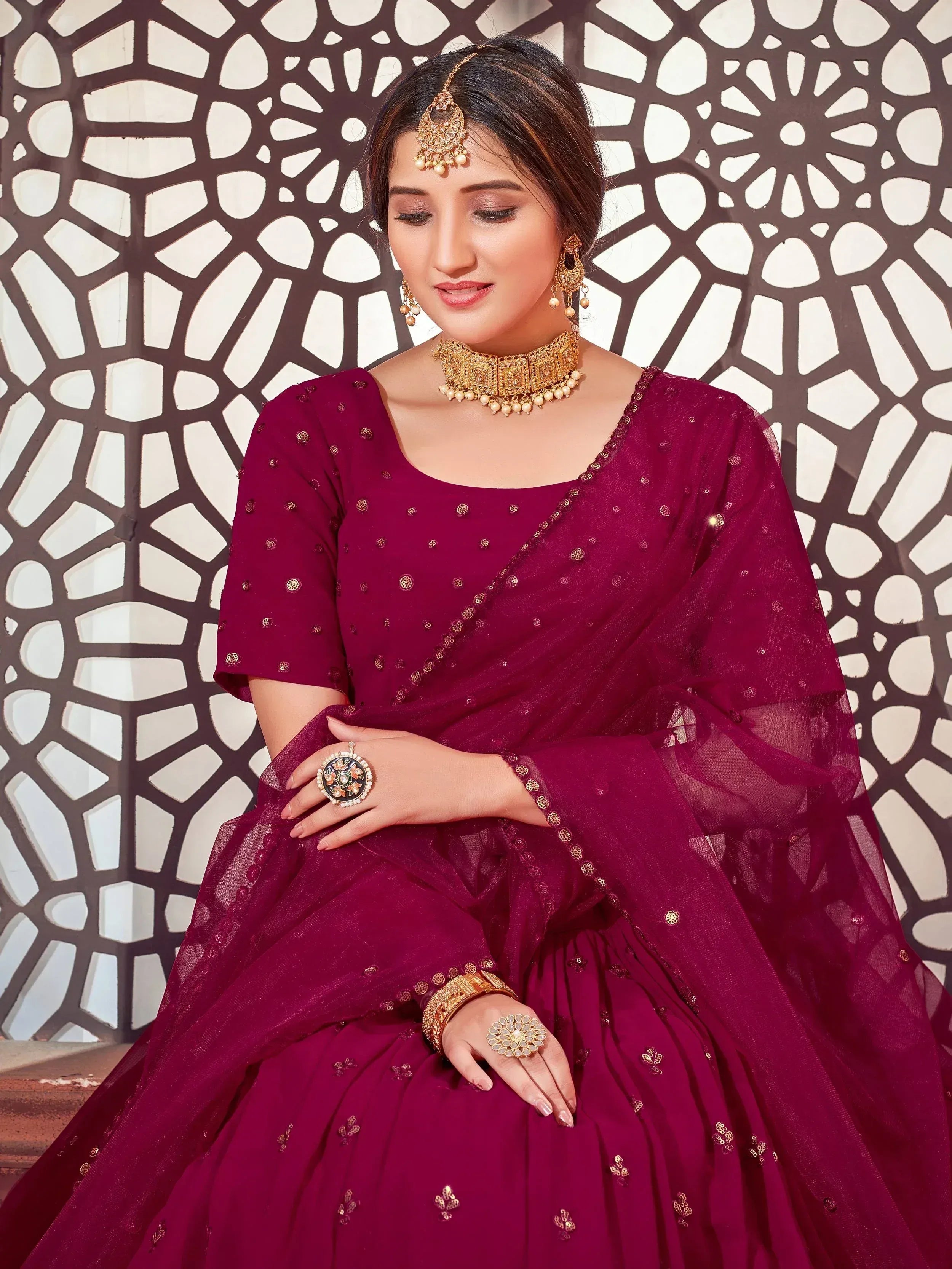 Elegant maroon designer lehenga choli with gold embroidery, perfect for Indian weddings and festive occasions.