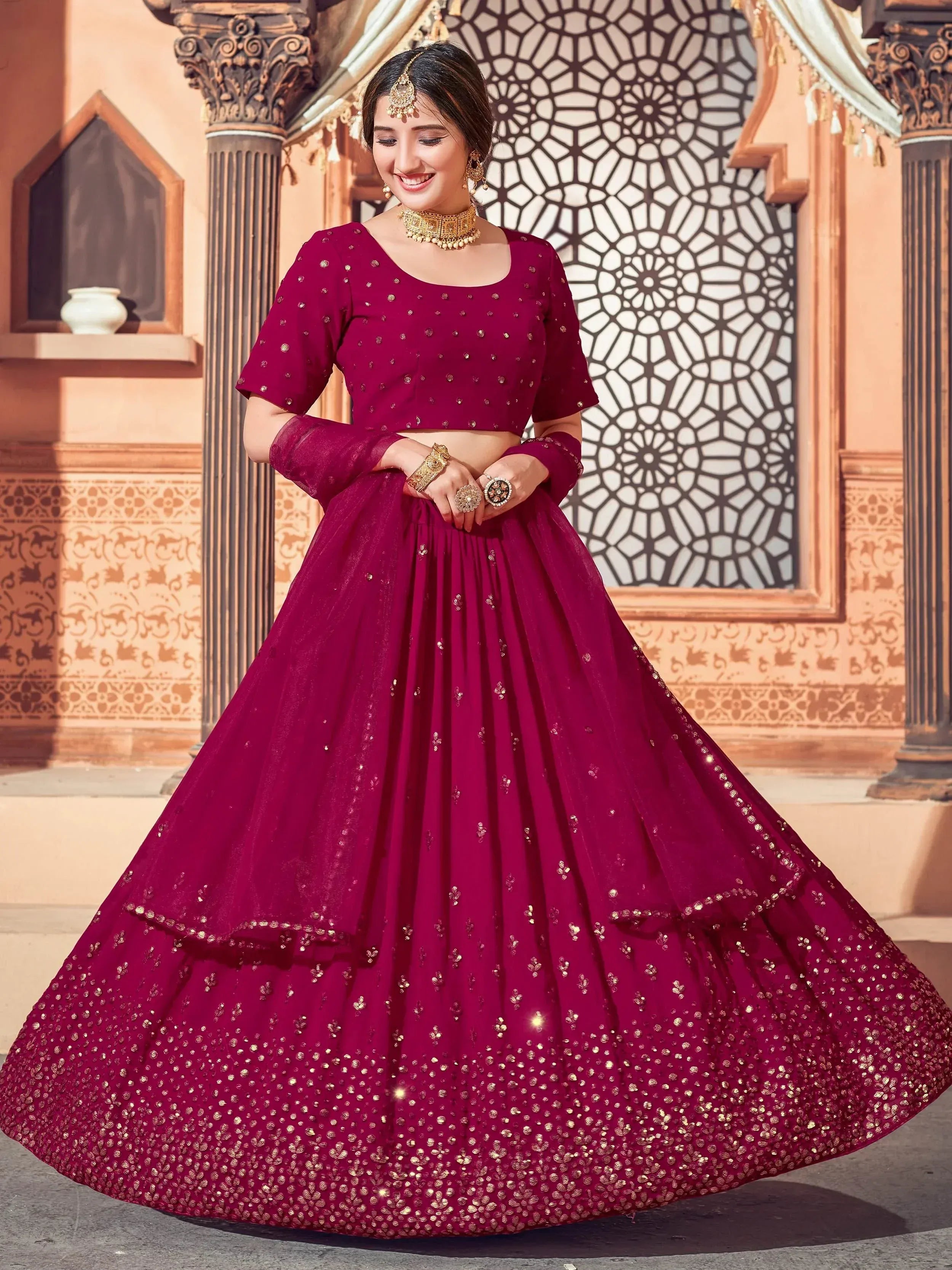 Burgundy designer lehenga choli with gold embroidery, perfect for Indian weddings and festive occasions.
