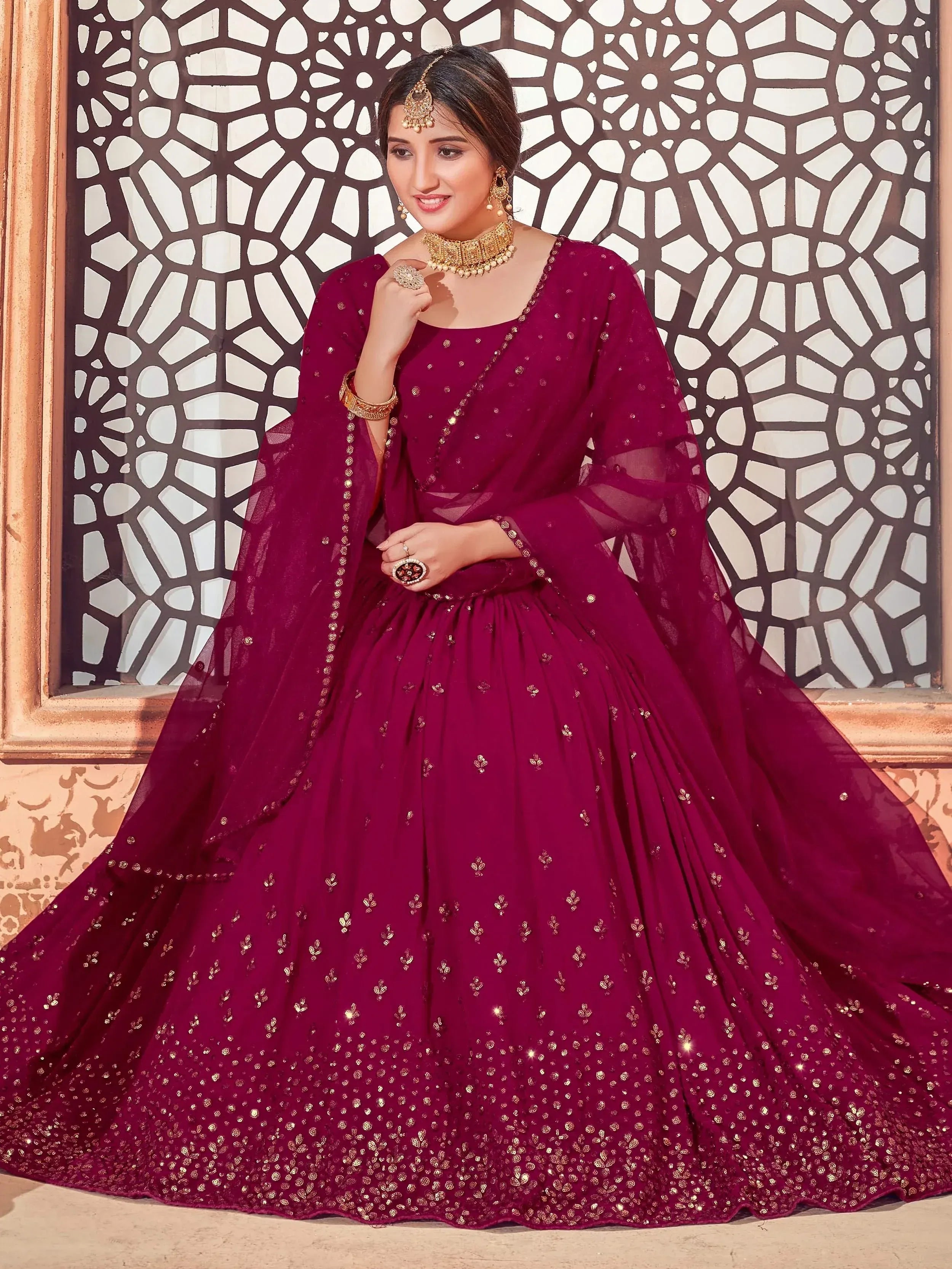 Elegant maroon designer lehenga choli with gold embroidery, perfect for Indian weddings and festive occasions.