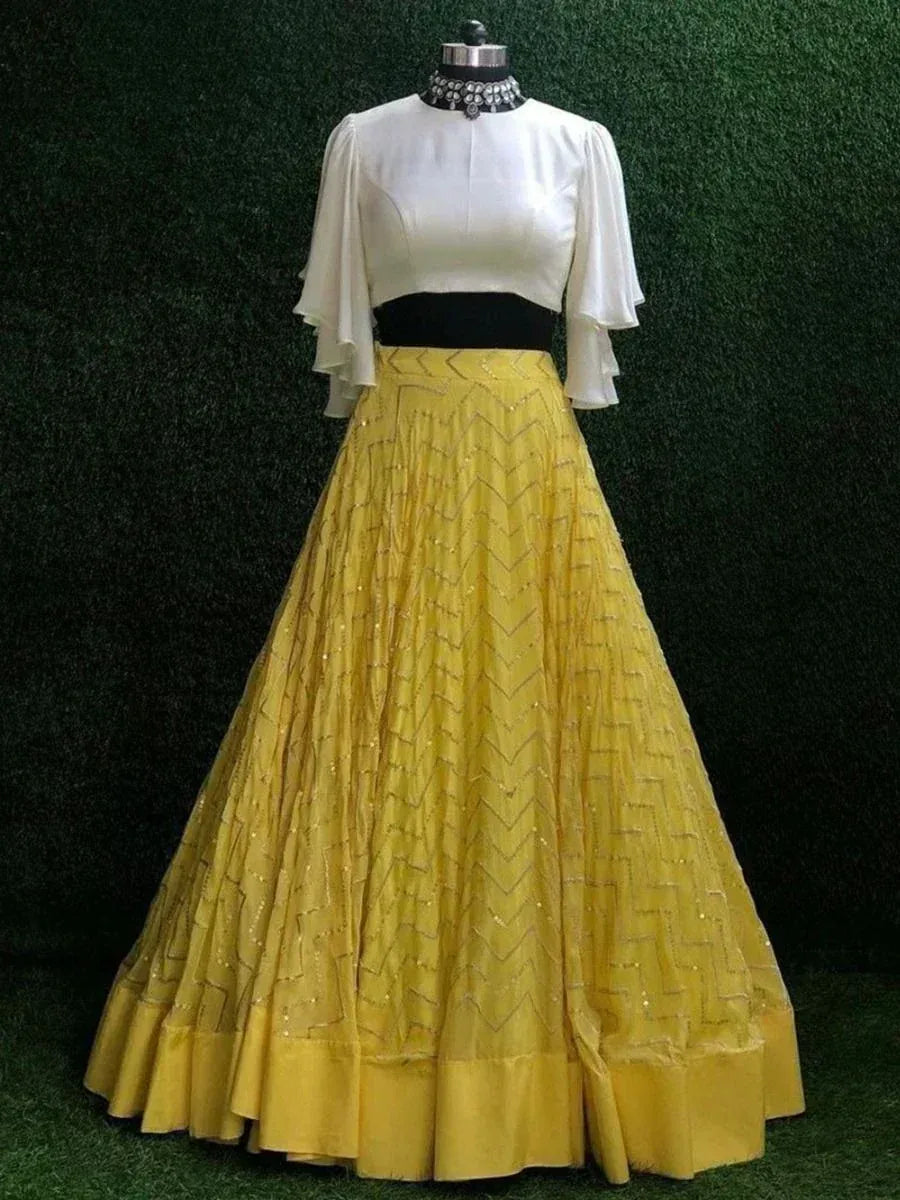 Yellow embroidered lehenga with white cape sleeve top, ethnic Indian wear for weddings or parties
