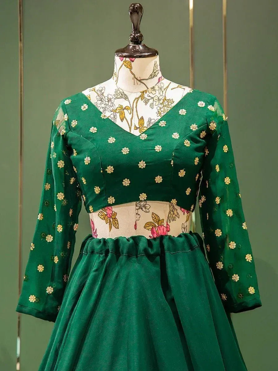 Emerald green ethnic gown with gold floral embroidery, V-neck, long sleeves, and flared skirt on mannequin
