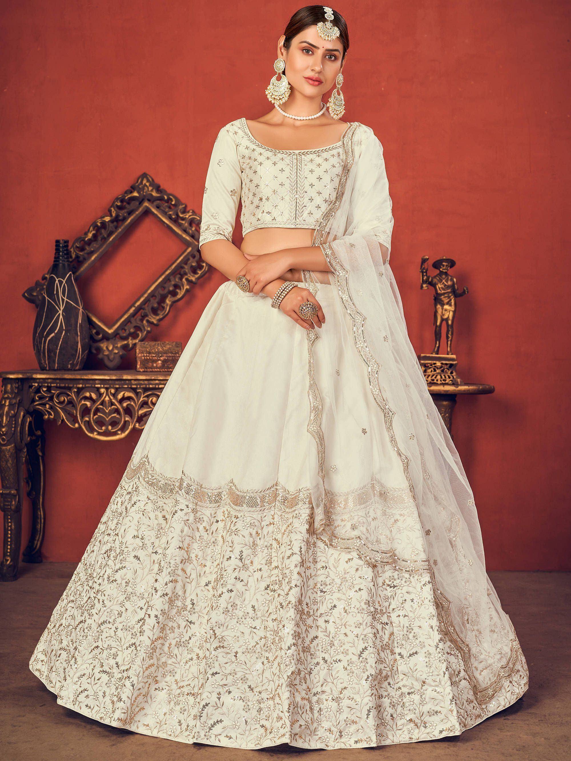 Elegant white embroidered lehenga choli with gold detailing, perfect for Indian weddings and festive occasions.