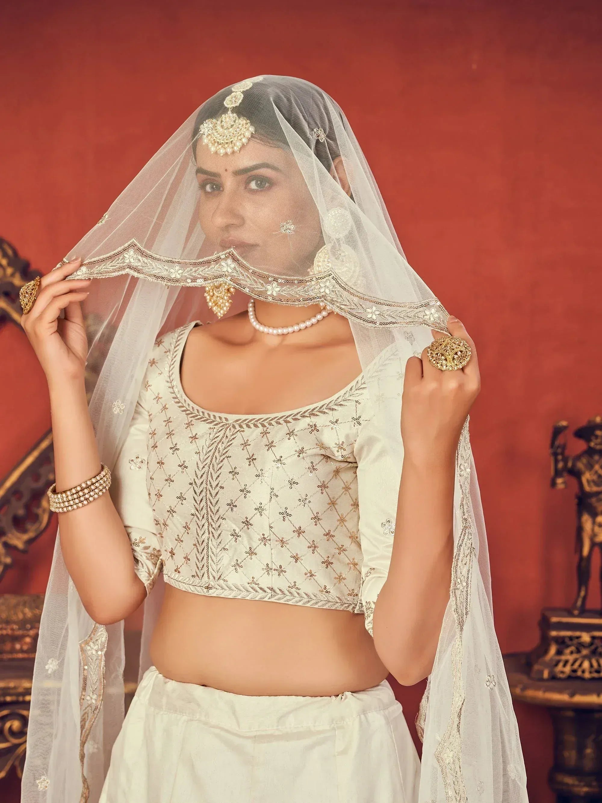 Elegant Indian bridal lehenga choli with intricate embroidery and pearl jewelry