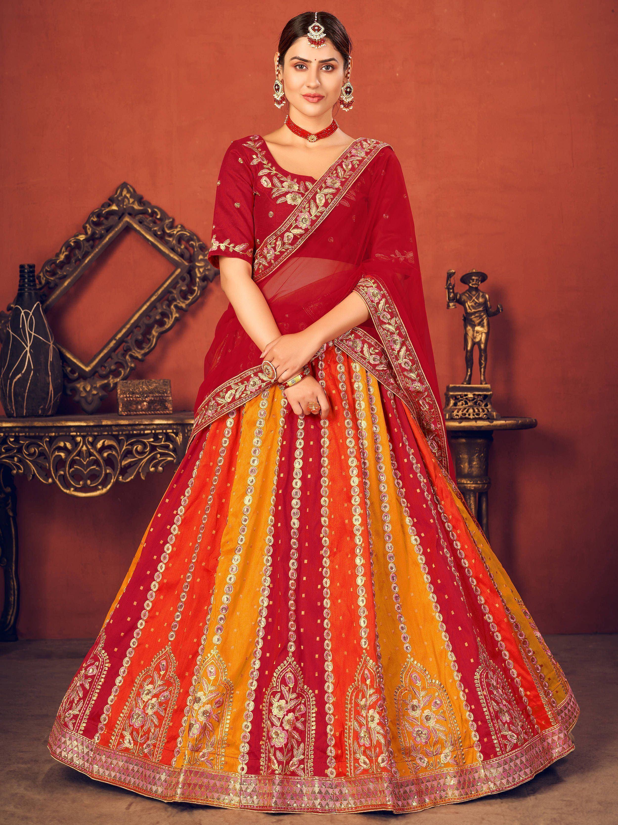 Red and yellow embroidered lehenga choli with floral detailing, perfect for Indian weddings and festive occasions.