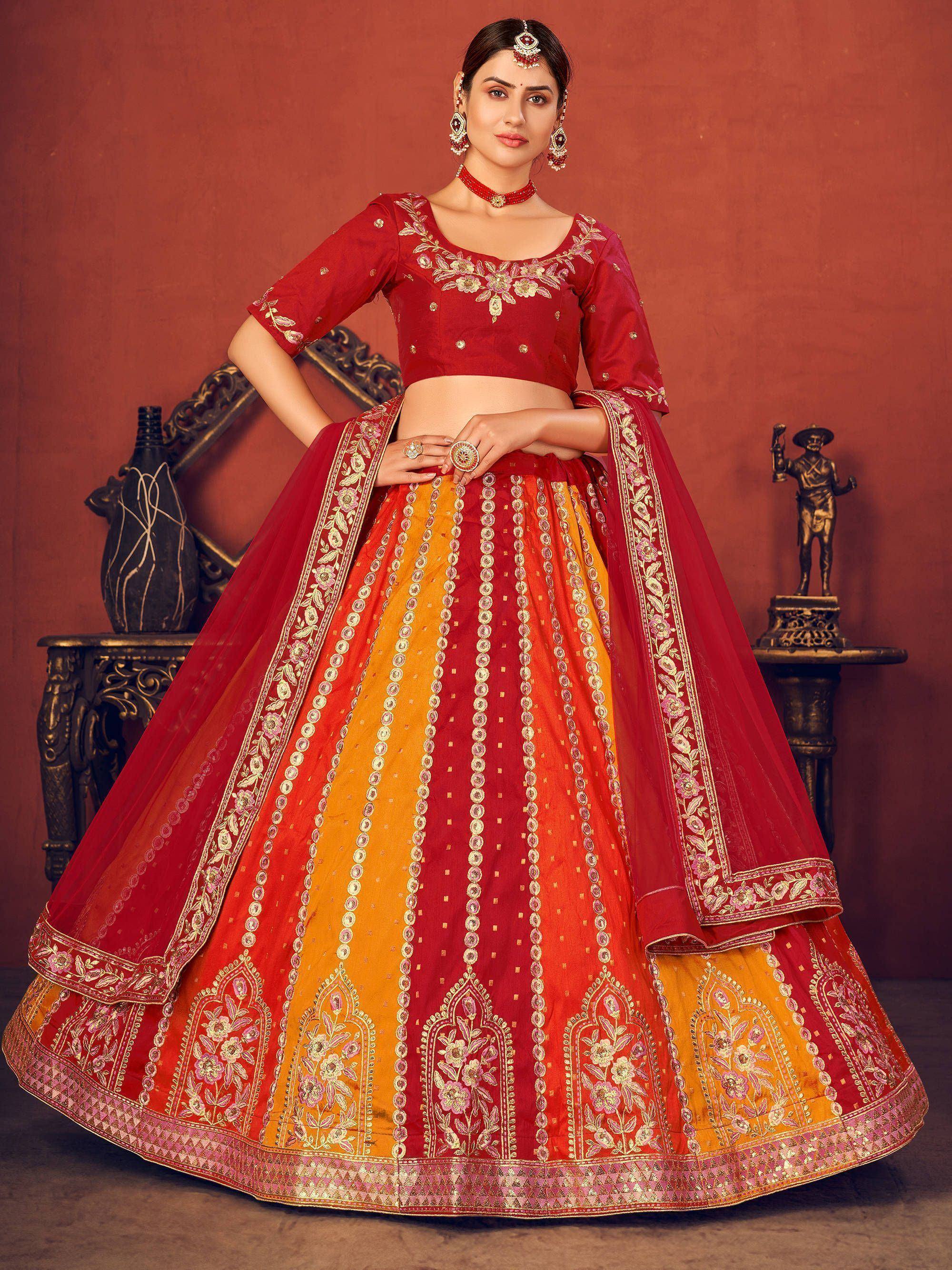 Red and yellow embroidered lehenga choli with floral motifs, perfect for Indian weddings and festive occasions.